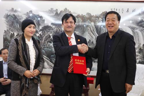 8、和田地區(qū)行政公署副專員楊渭鋒向艾買·依民提夫婦頒發(fā)榮譽(yù)證書。.jpg